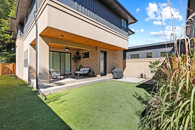 rear view of house featuring ceiling fan, a yard, a patio, and an outdoor living space