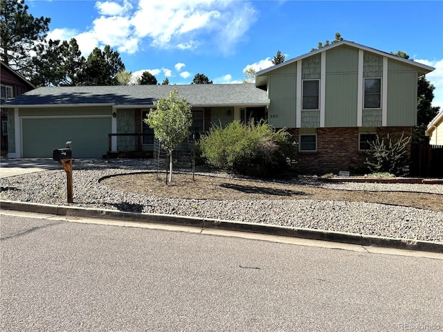 280 Raven Hills Rd, Colorado Springs, CO 80919 - split level home featuring brick siding, an attached garage, and driveway