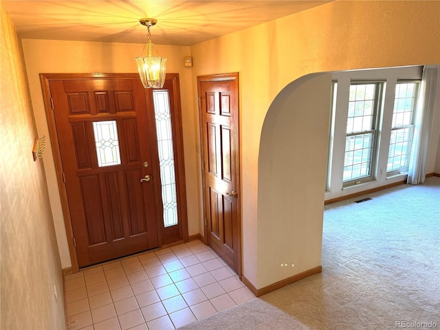280 Raven Hills Rd, Colorado Springs, CO 80919 - entrance foyer with baseboards, arched walkways, a chandelier, and light carpet