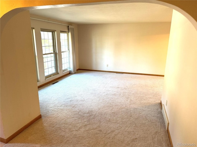 280 Raven Hills Rd, Colorado Springs, CO 80919 - carpeted empty room featuring arched walkways, baseboards, and visible vents