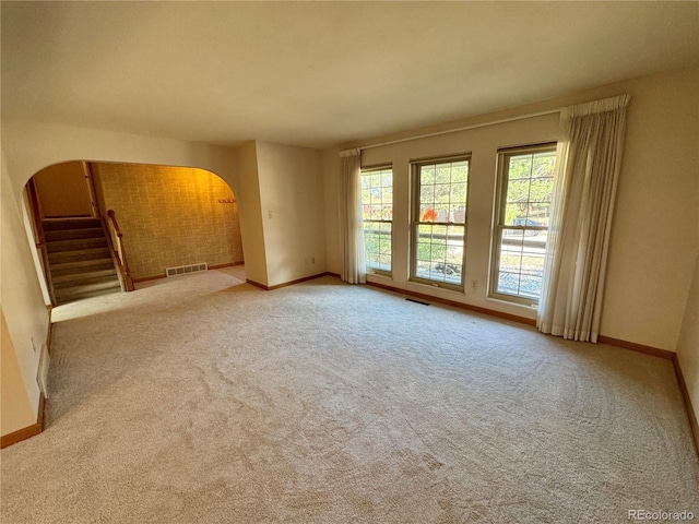 280 Raven Hills Rd, Colorado Springs, CO 80919 - carpeted spare room with stairway, arched walkways, baseboards, and visible vents