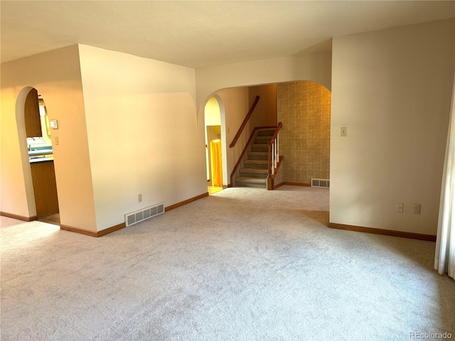 280 Raven Hills Rd, Colorado Springs, CO 80919 - unfurnished living room featuring arched walkways, carpet flooring, and visible vents