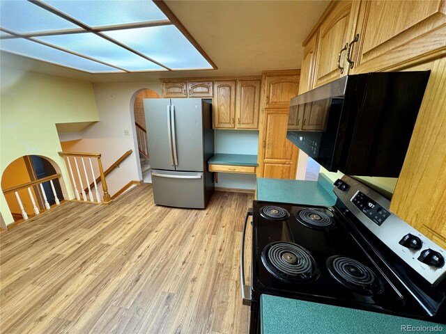 280 Raven Hills Rd, Colorado Springs, CO 80919 - kitchen with light brown cabinets, built in study area, baseboards, light wood-style flooring, and appliances with stainless steel finishes