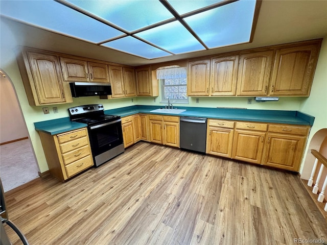 280 Raven Hills Rd, Colorado Springs, CO 80919 - kitchen with light wood-style floors, baseboards, arched walkways, a sink, and appliances with stainless steel finishes