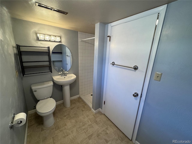 280 Raven Hills Rd, Colorado Springs, CO 80919 - bathroom featuring visible vents, baseboards, a tile shower, and toilet