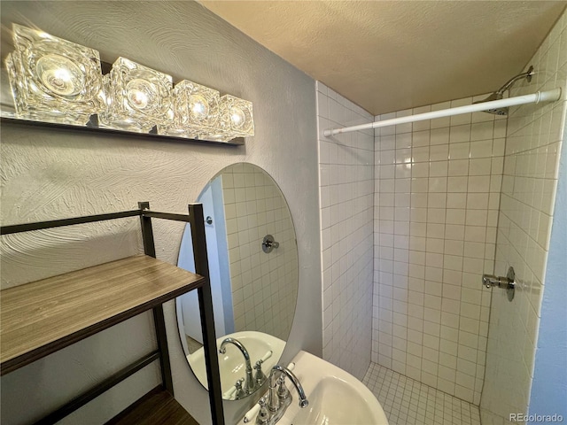 280 Raven Hills Rd, Colorado Springs, CO 80919 - full bath with a textured ceiling, a textured wall, a tile shower, and a sink
