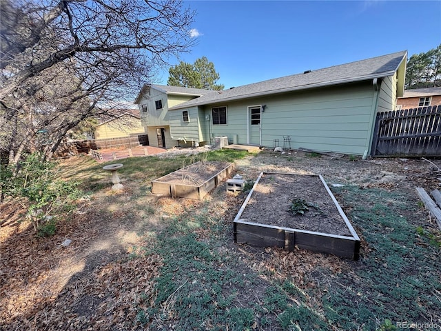280 Raven Hills Rd, Colorado Springs, CO 80919 - rear view of property featuring central AC, fence, and a vegetable garden