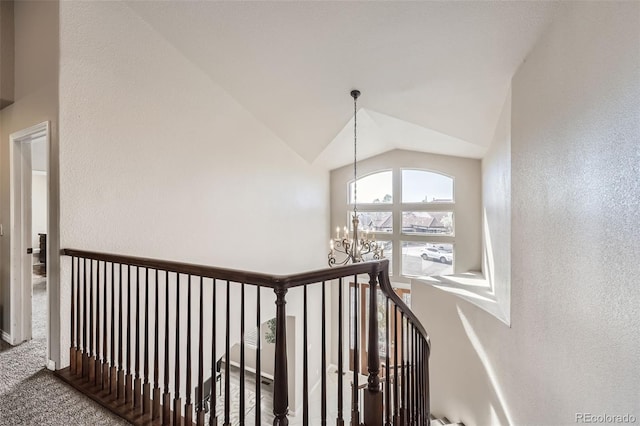 stairs with a textured wall, vaulted ceiling, carpet flooring, and a notable chandelier