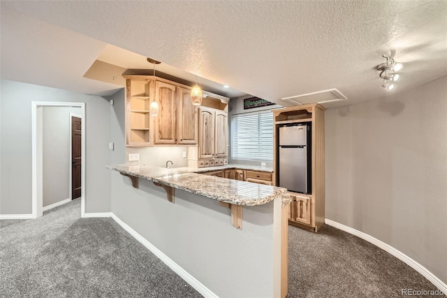 kitchen featuring open shelves, a breakfast bar, dark colored carpet, freestanding refrigerator, and a peninsula