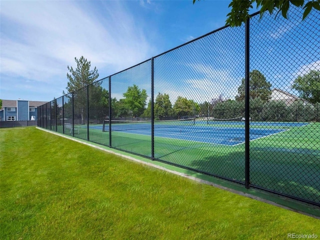 view of sport court with a yard and fence