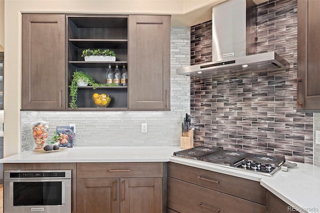 9468 E Aspen Hill Ln, Lone Tree, CO 80124 - kitchen featuring wall chimney range hood, appliances with stainless steel finishes, backsplash, open shelves, and light countertops