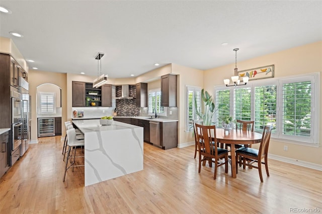 9468 E Aspen Hill Ln, Lone Tree, CO 80124 - kitchen featuring wine cooler, open shelves, stainless steel dishwasher, a center island, and light wood-type flooring