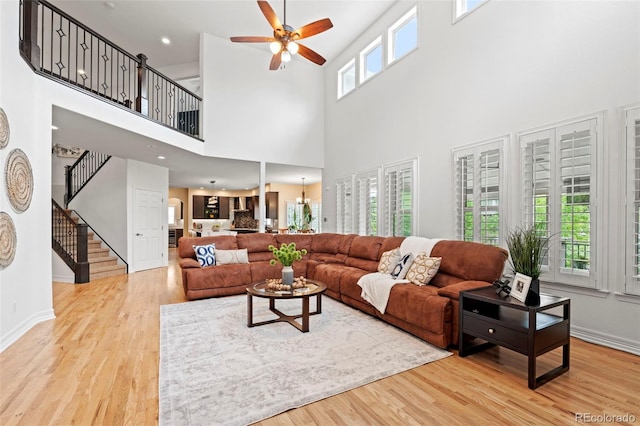 9468 E Aspen Hill Ln, Lone Tree, CO 80124 - living area with stairs, a ceiling fan, wood finished floors, and a high ceiling