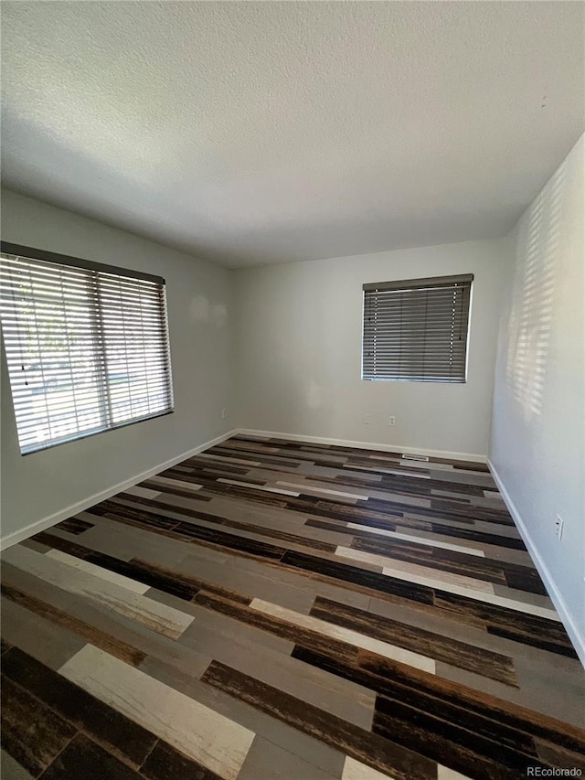 2604 S Dunkirk Ct, Aurora, CO 80013 - spare room featuring baseboards, wood finished floors, and a textured ceiling