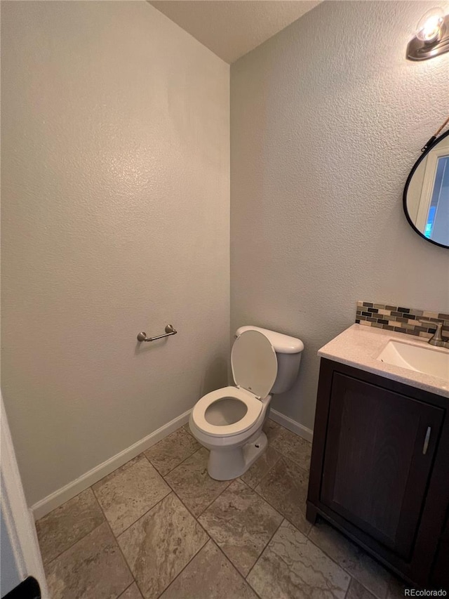 2604 S Dunkirk Ct, Aurora, CO 80013 - half bath with toilet, vanity, baseboards, and backsplash
