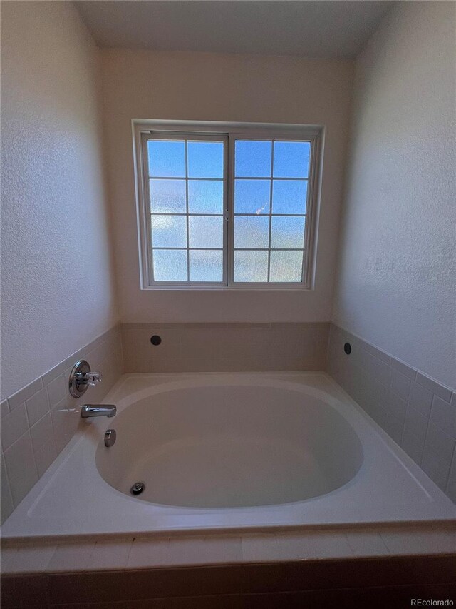 2604 S Dunkirk Ct, Aurora, CO 80013 - full bathroom featuring a textured wall and a bath