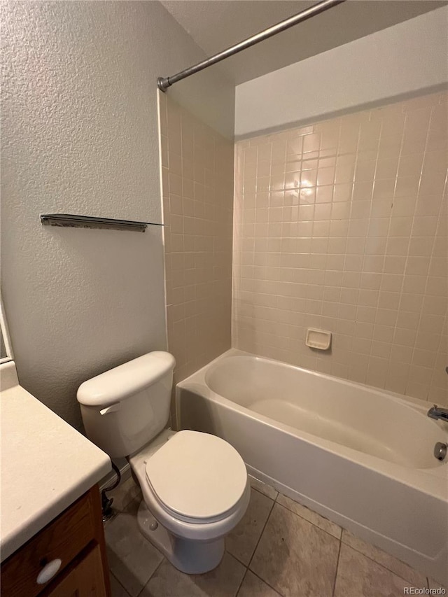 full bathroom with tiled shower / bath, vanity, toilet, and tile patterned floors