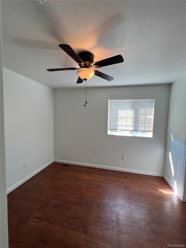 unfurnished room featuring a textured ceiling, dark hardwood / wood-style floors, and ceiling fan