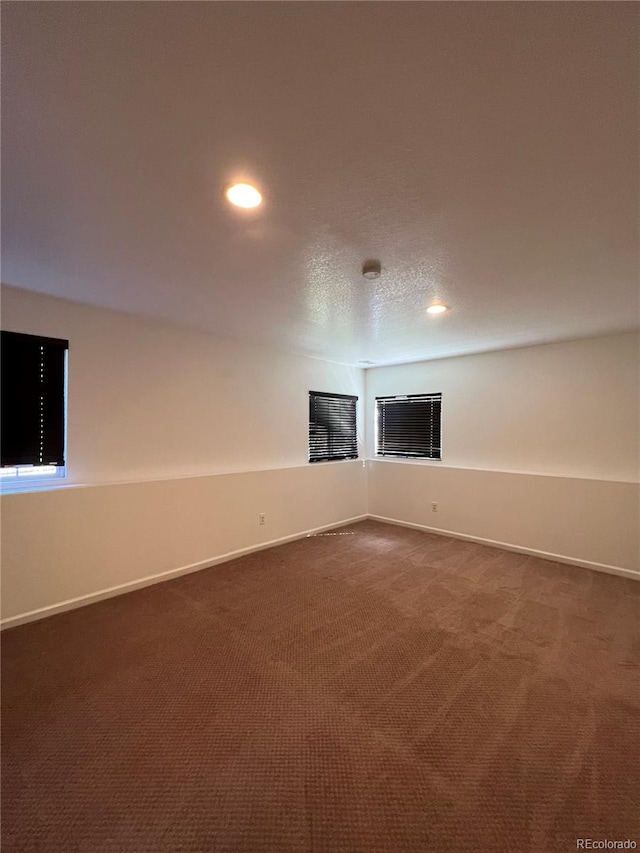 spare room with dark colored carpet