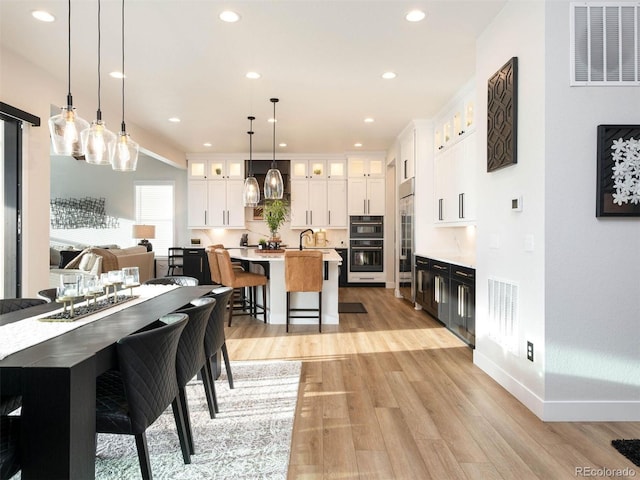 dining space with light wood-type flooring, visible vents, baseboards, and recessed lighting