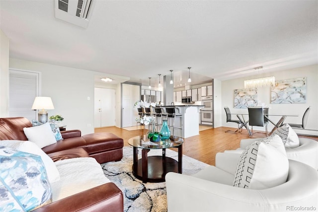 3131 E Alameda Ave Unit 803, Denver, CO 80209 - living room with light wood finished floors and a chandelier