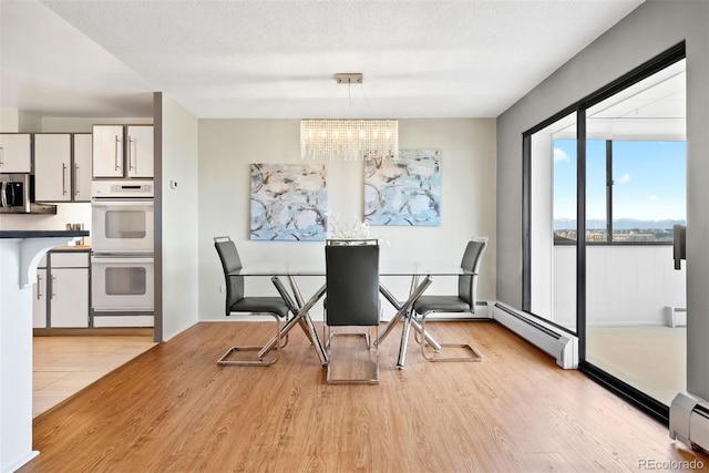 3131 E Alameda Ave Unit 803, Denver, CO 80209 - dining area featuring light wood-type flooring, a chandelier, a baseboard radiator, and baseboard heating