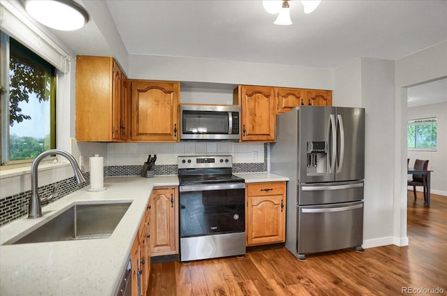 1010 Vondelpark Dr, Colorado Springs, CO 80907 - kitchen with stainless steel appliances, brown cabinetry, tasteful backsplash, and dark wood-style floors