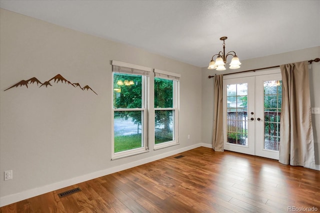 1010 Vondelpark Dr, Colorado Springs, CO 80907 - empty room with french doors, healthy amount of natural light, a chandelier, and wood finished floors
