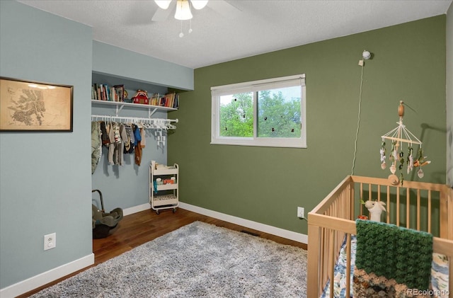 1010 Vondelpark Dr, Colorado Springs, CO 80907 - bedroom featuring wood finished floors, a crib, a ceiling fan, a textured ceiling, and a closet