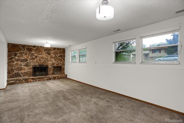 1010 Vondelpark Dr, Colorado Springs, CO 80907 - unfurnished living room with a textured ceiling, a stone fireplace, and carpet flooring