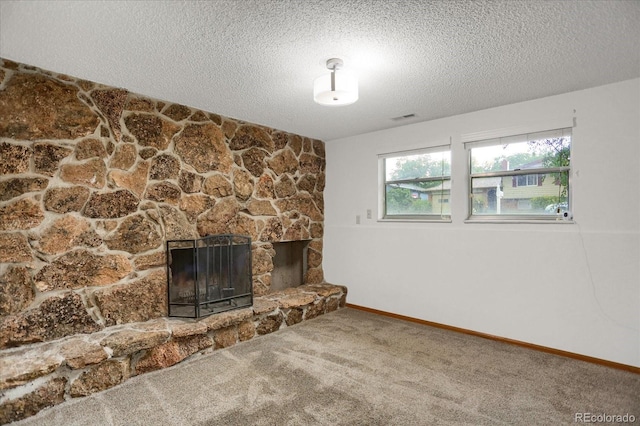 1010 Vondelpark Dr, Colorado Springs, CO 80907 - unfurnished living room featuring a stone fireplace, carpet flooring, and a textured ceiling