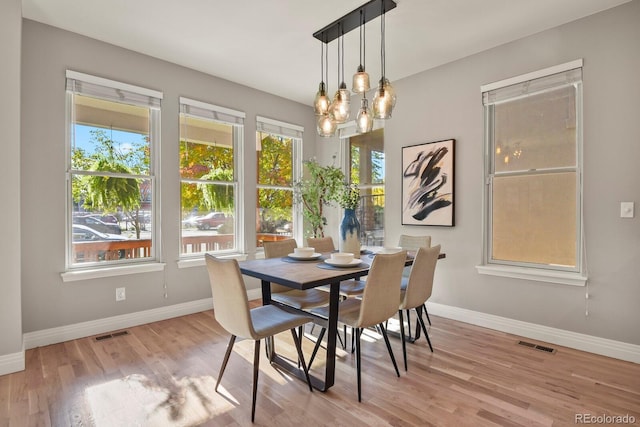 dining space with an inviting chandelier and light wood-type flooring