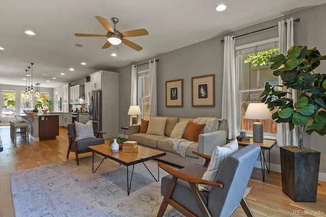 living room featuring ceiling fan and light wood-type flooring