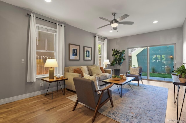 living room with ceiling fan and light hardwood / wood-style flooring