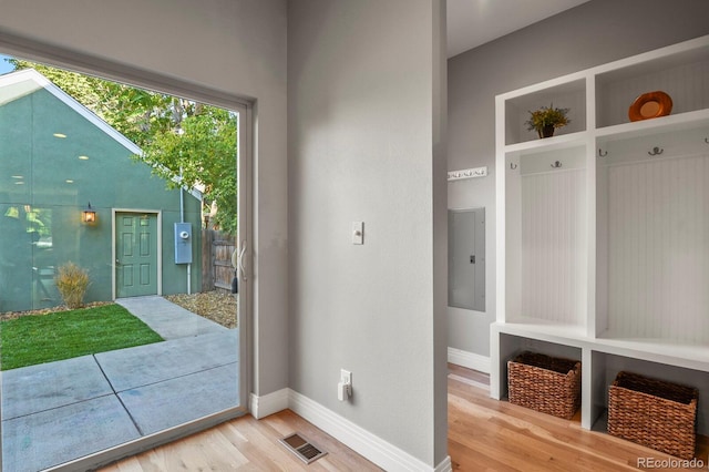 mudroom with electric panel and light hardwood / wood-style floors