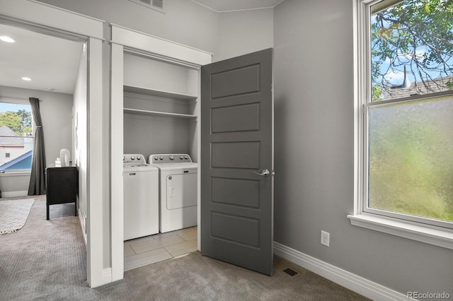 laundry area with separate washer and dryer and light colored carpet