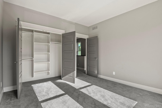 unfurnished bedroom with dark colored carpet and a closet