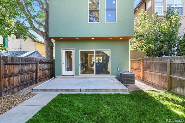 back of property featuring a yard, cooling unit, and a patio area