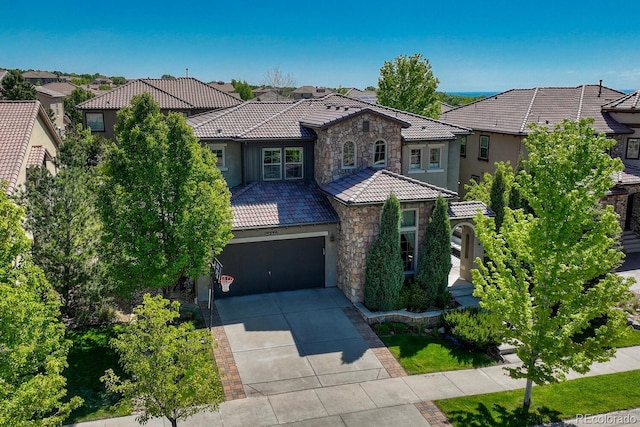 15235 W Iliff Ave, Lakewood, CO 80228 - mediterranean / spanish-style house featuring stone siding, a tiled roof, driveway, a residential view, and stucco siding