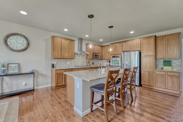 15235 W Iliff Ave, Lakewood, CO 80228 - kitchen featuring wall chimney exhaust hood, appliances with stainless steel finishes, a sink, light wood-type flooring, and recessed lighting