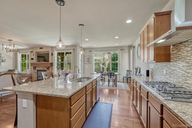 15235 W Iliff Ave, Lakewood, CO 80228 - kitchen featuring wall chimney exhaust hood, appliances with stainless steel finishes, a sink, wood finished floors, and backsplash