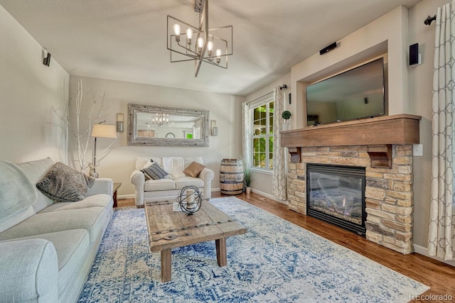 15235 W Iliff Ave, Lakewood, CO 80228 - living room with a chandelier, a fireplace, wood finished floors, and baseboards