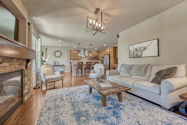 15235 W Iliff Ave, Lakewood, CO 80228 - living room featuring a chandelier, wood finished floors, recessed lighting, a stone fireplace, and baseboards