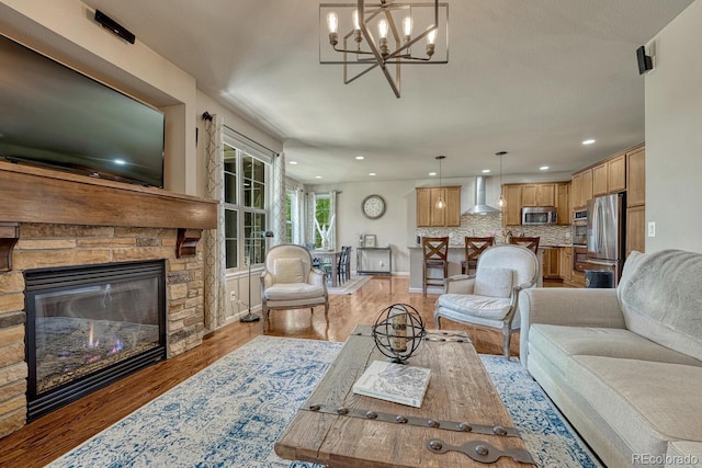15235 W Iliff Ave, Lakewood, CO 80228 - living area with light wood-style flooring, a fireplace, a chandelier, recessed lighting, and baseboards