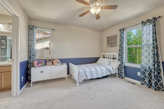15235 W Iliff Ave, Lakewood, CO 80228 - bedroom with light carpet, baseboards, a ceiling fan, a sink, and ensuite bathroom