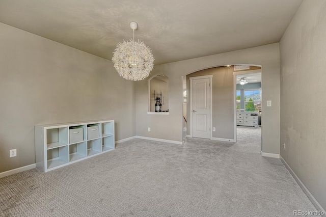15235 W Iliff Ave, Lakewood, CO 80228 - carpeted empty room with arched walkways, baseboards, and a chandelier