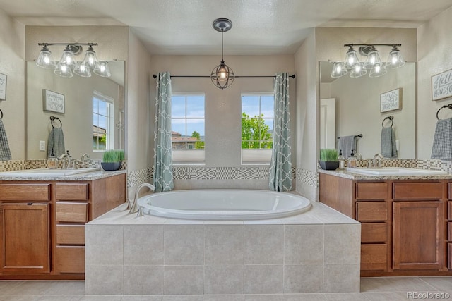 15235 W Iliff Ave, Lakewood, CO 80228 - full bath featuring tile patterned flooring, a bath, two vanities, and a textured ceiling