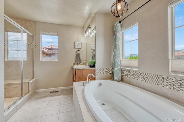 15235 W Iliff Ave, Lakewood, CO 80228 - bathroom with vanity, a bath, a shower stall, tile patterned floors, and a textured ceiling