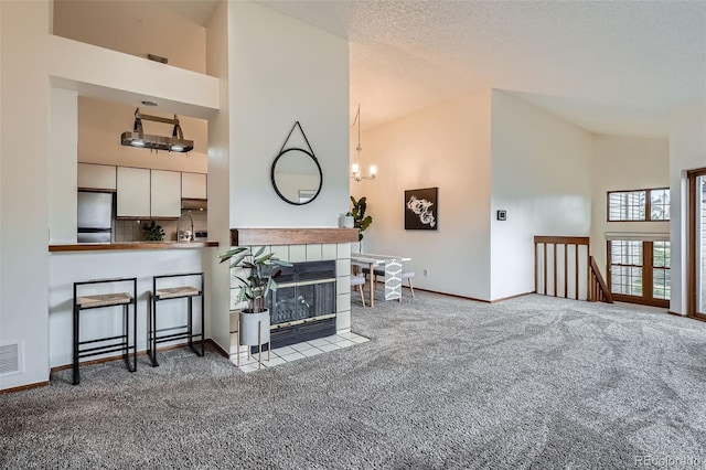 1661 S Fulton St, Aurora, CO 80247 - living area with carpet, high vaulted ceiling, baseboards, and a tile fireplace