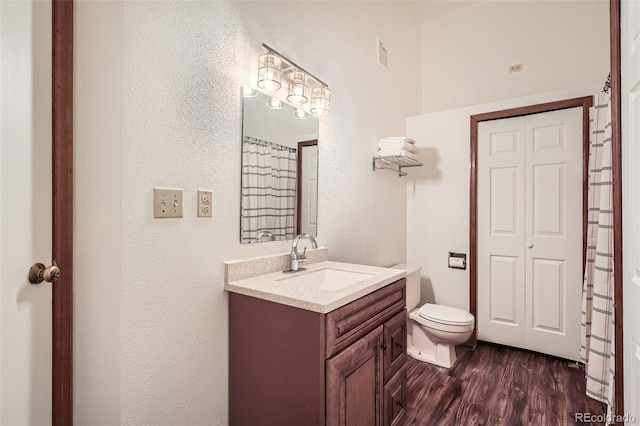 1661 S Fulton St, Aurora, CO 80247 - full bath with vanity, toilet, wood finished floors, and a textured wall